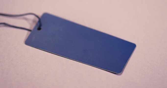 empty tag for indicating the price and other information, an old clothing tag that is not filled in, which contains information important to customers