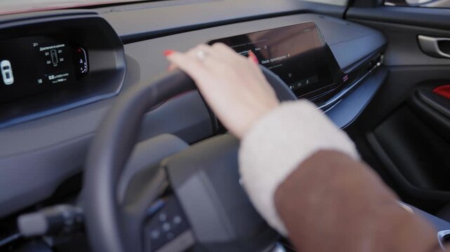 A woman driving a modern car. Electronic dashboard.