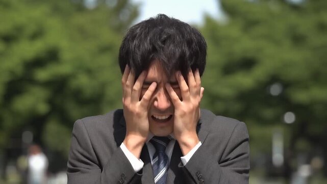 ショックを受けて絶望しているスーツの20代男性