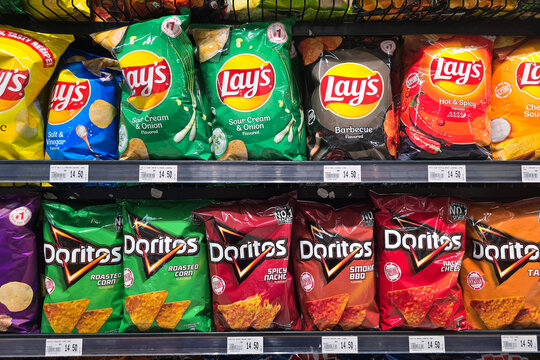 Kuala Lumpur, Malaysia &ndash; Sep 14, 2025: A supermarket snack aisle at Jaya Grocer displaying an assortment of Lay&rsquo;s and Doritos chips in vibrant packaging.