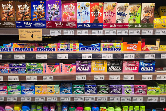 Kuala Lumpur, Malaysia &ndash; Sep 14, 2025: A colorful assortment of Pocky biscuit sticks, Mentos chewy mints, and Halls candies displayed on supermarket shelves at Jaya Grocer.
