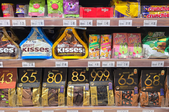 Kuala Lumpur, Malaysia &ndash; Sep 14, 2025: A colorful supermarket shelf at Jaya Grocer displaying a range of chocolates and confectionery includes Hershey&rsquo;s Kisses, Benns vegan dark chocolate.
