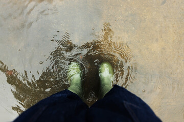 POV shot of person with Rain Boots standing in Floodwater.