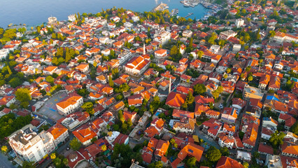 Fototapeta premium Antalya, Turkey. Aerial view of Kaleici Old Town with narrow streets, terracotta roofs, lush green trees along Mediterranean coastline in morning light.. Aerial View