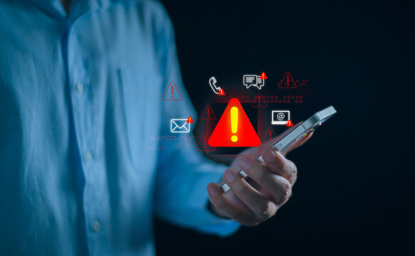 Businessman using smartphone with system warning alerts, Concept of cyber threat, phishing, scam messages, suspicious calls, and online security risks on communication.
