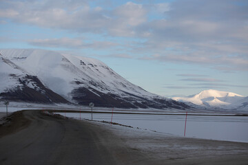 Longyerbeyen, Svalbard, Road with a snowy mountain in the background. The road is empty and the sky is cloudy