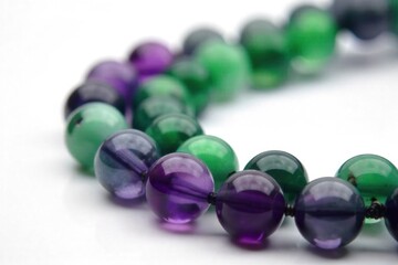 A collection of shimmering glass beads in various shapes, arranged in a gradient of colors on a white background. A visually stunning gradient of shimmering glass beads, transitioning smoothly from