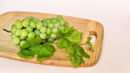 Green grapes on a wooden board, close-up composition