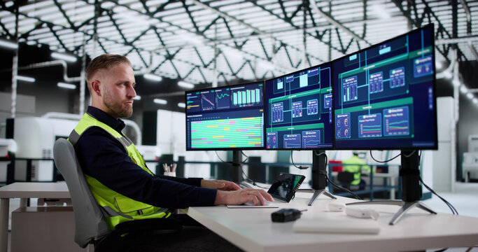 Man Wearing Helmet Monitors Factory Production