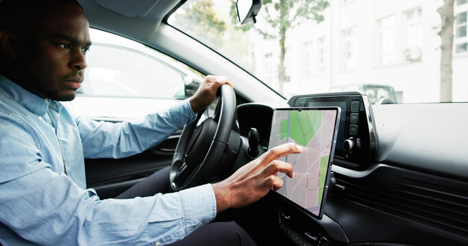 Man Navigating With GPS Map On Car Dashboard As Auto Navigator