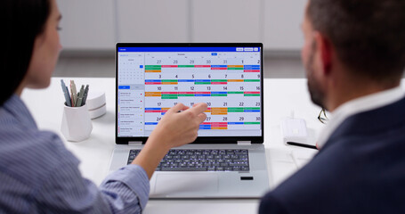 Busy Professionals Planning Meeting Using Online Calendar