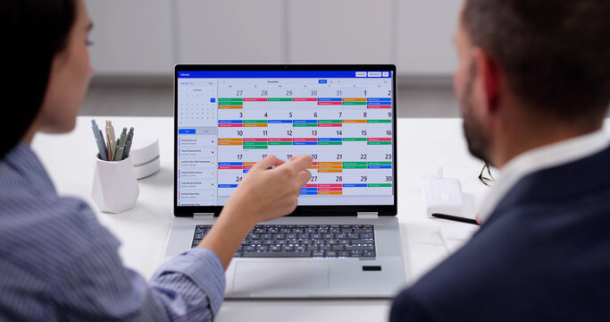 Busy Professionals Planning Meeting Using Online Calendar