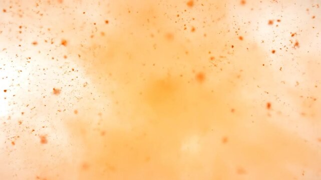 Abstract orange and white explosion with scattered particles, gradient effect, and soft focus