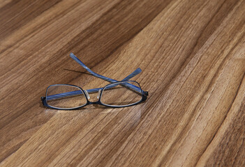 Pair of blue reading glasses on a timber desk
