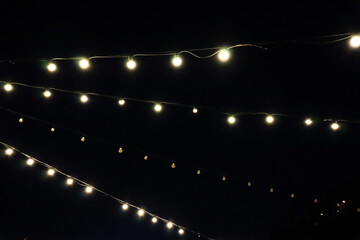 Light bulbs. Electric garland at night. City night illumination.