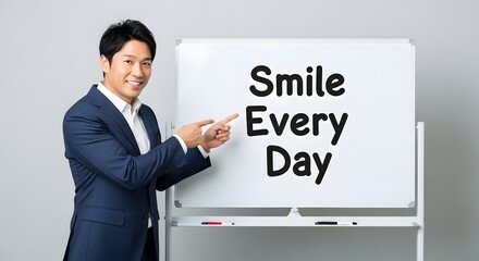 A professional man in a suit smiling and pointing at a whiteboard with the motivational message 'Smile Every Day' written on it in a bright, modern office environment