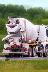 Big concrete lorry driving on asphalt countryside road
