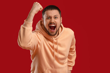 Screaming young man on red background