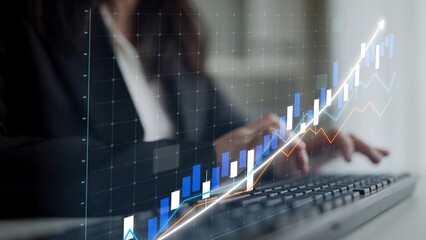 A businesswoman focuses on data trends with a graphical overlay, symbolizing financial growth in a...