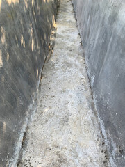 Narrow Concrete Drainage Channel with Weathered Surface