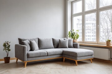 Fototapeta premium A modern sectional sofa with plants and a large window in a bright room.