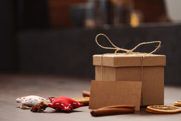 Christmas gift box from eco friendly paper wrapped with natural twine on wood table with natural decorations and stay safe card