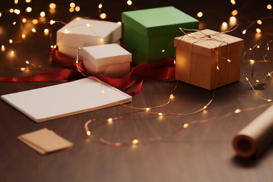 White paper notepad with pencil on wood table with christmas decorations