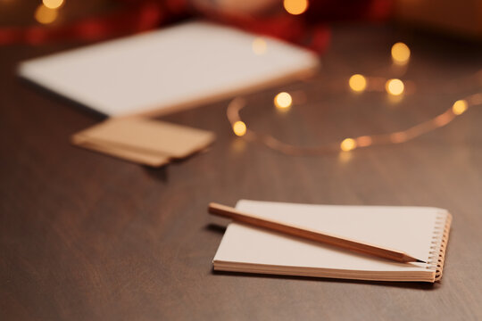 White paper notepad with pencil on wood table with christmas decorations - Powered by Adobe