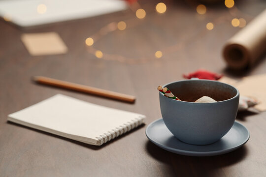 Cup of hot chocolate next to notepad and christmas decorations - Powered by Adobe