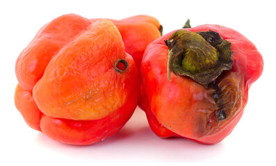 Rotten red bell peppers isolated on white background