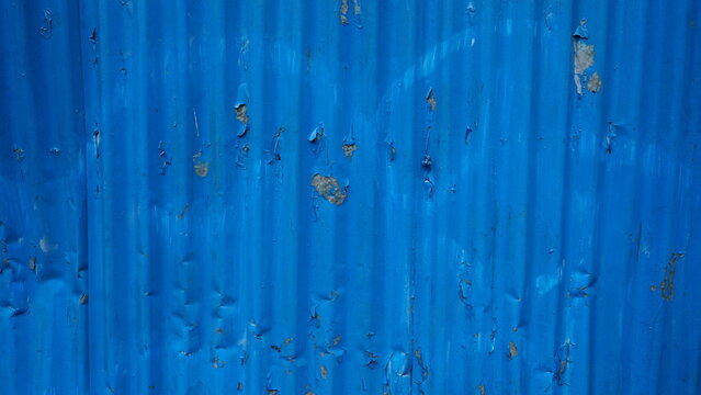 Close-up of blue corrugated metal sheet with peeling paint