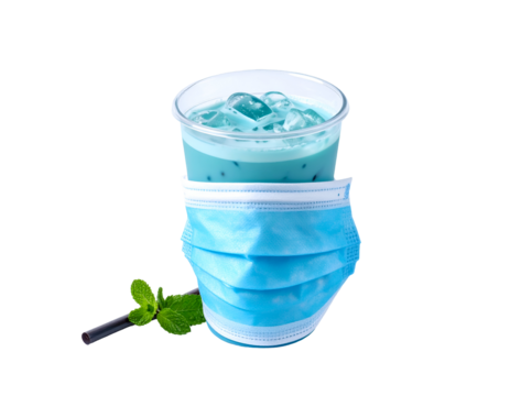 A refreshing blue beverage with ice cubes placed inside a transparent cup, partially covered by a disposable face mask and accompanied by mint leaves and a straw - Powered by Adobe