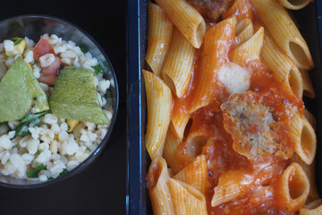 Delicious pasta and salad meal served in a takeout container