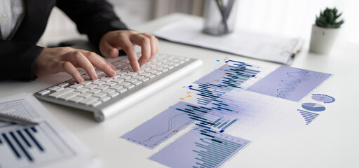 A businessman engages with digital financial data on a modern desk, balancing analysis and...