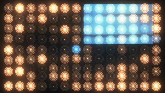 Grid of circular lights with warm yellow-orange and bright blue illuminated pattern on dark background