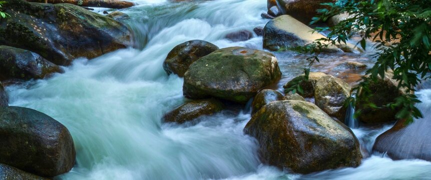 Rushing mountain stream over smooth boulders - Powered by Adobe