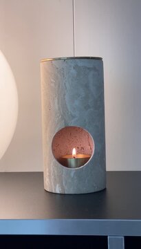 Lighting a candle in cozy home interior &ndash; relaxing warm light and calm evening atmosphere
