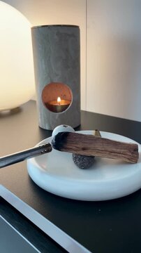 Burning incense wood for relaxation &ndash; aromatic smoke rising in cozy home interior with warm calm atmosphere
