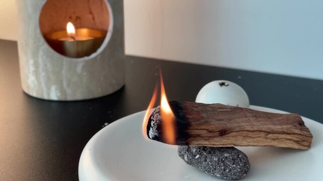Burning incense wood for relaxation &ndash; aromatic smoke rising in cozy home interior with warm calm atmosphere
