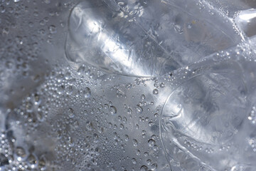 Macro detail of cold frozen ice cube with trapped air bubble. Clear refreshing water condensation on textured surface. cool, serene, abstract background concept for purity