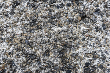 Close up macro detail of rugged grey rock surface. natural stone background shows coarse mineral texture with black and white pattern perfect for abstract design