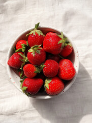 Bright Bowl Of Fresh Red Strawberries On White Linen Tabletop, Vibrant Summer Fruit Now Displayed