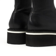 Détail Botte en cuir noir à la mode sur fond blanc