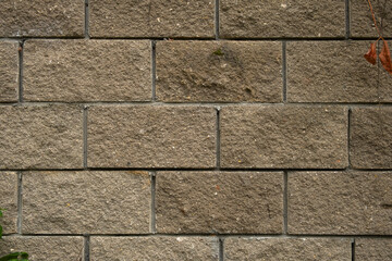 Concrete grey block texture. Cinder block fence close-up. Solid horizontal background for the design. Smooth blocks in staggered order. The construction of the walls of the outer fence. Copy space