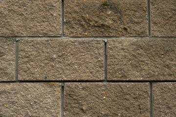 Concrete grey block texture. Cinder block fence close-up. Solid horizontal background for the design. Smooth blocks in staggered order. The construction of the walls of the outer fence. Copy space