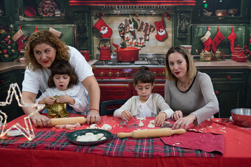Family with children baking christmas cookies in kitchen