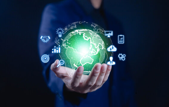 Businessman holding a glowing digital globe with technology and data icons, symbolizing global business, innovation, cloud computing, and digital transformation for modern enterprises.