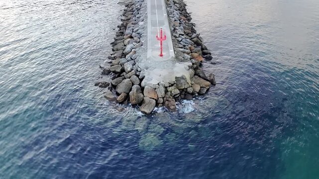 Scenic, real-time shot of colorful traditional fishing boats moored in the small, quaint port of Cand&aacute;s, Asturias, Spain. Historic coastal town architecture surrounds the harbor on a cloudy day