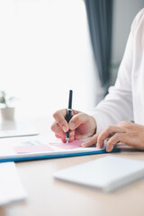 Concept of business planning and financial analysis. A businesswoman writes notes on documents with...