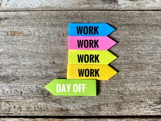 Four colorful arrow sticky notes reading 'WORK' stacked above a green sticky note reading 'DAY OFF'.